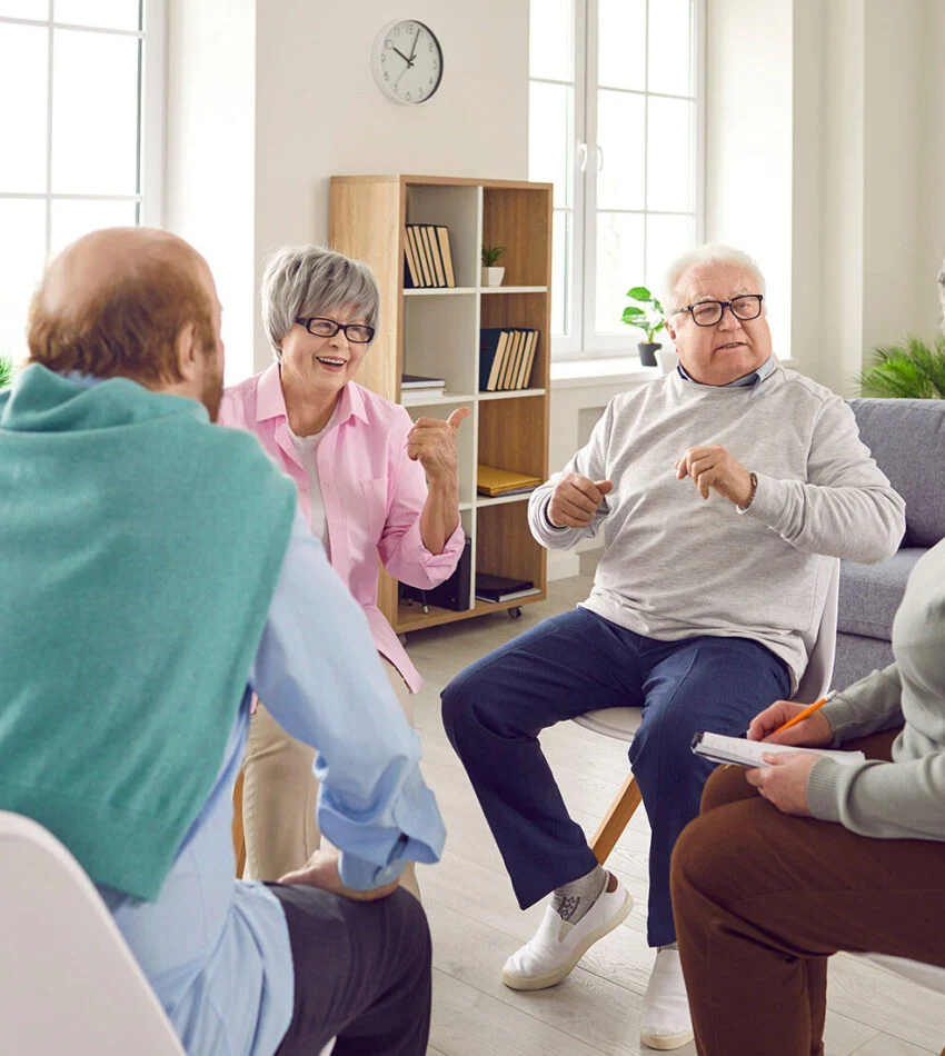 Older adults talking together in a circle of chairs