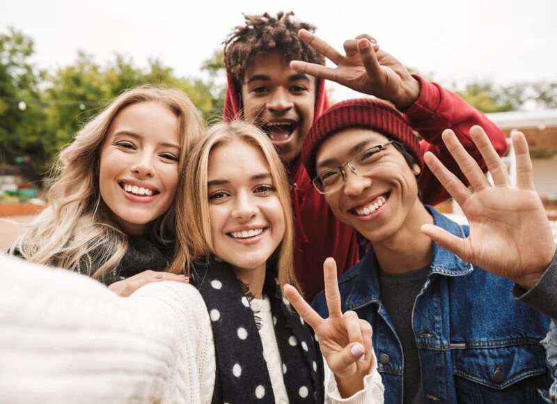 Teens laughing and taking a group selfie