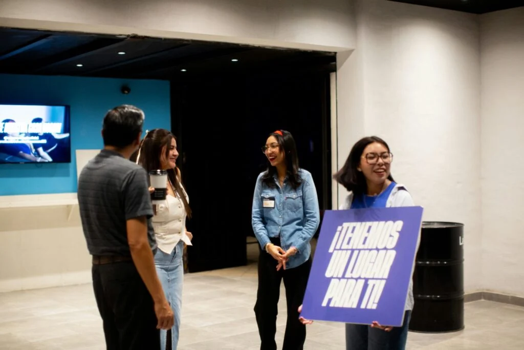 Greeters holding a welcome sign at the Downtown campus